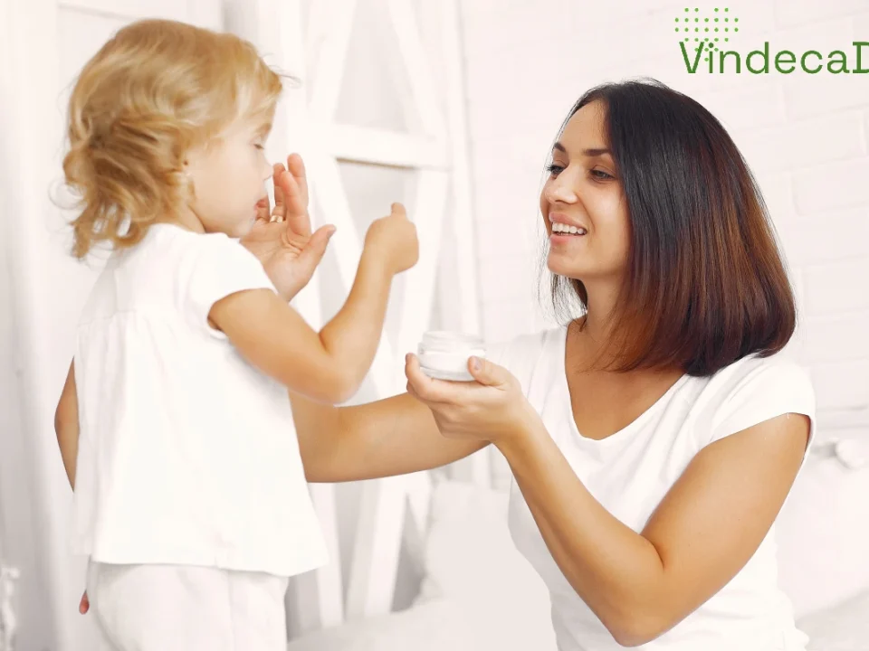 Mama punand crema pe fata fetitei sale