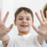 Copil care isi arata mainile
